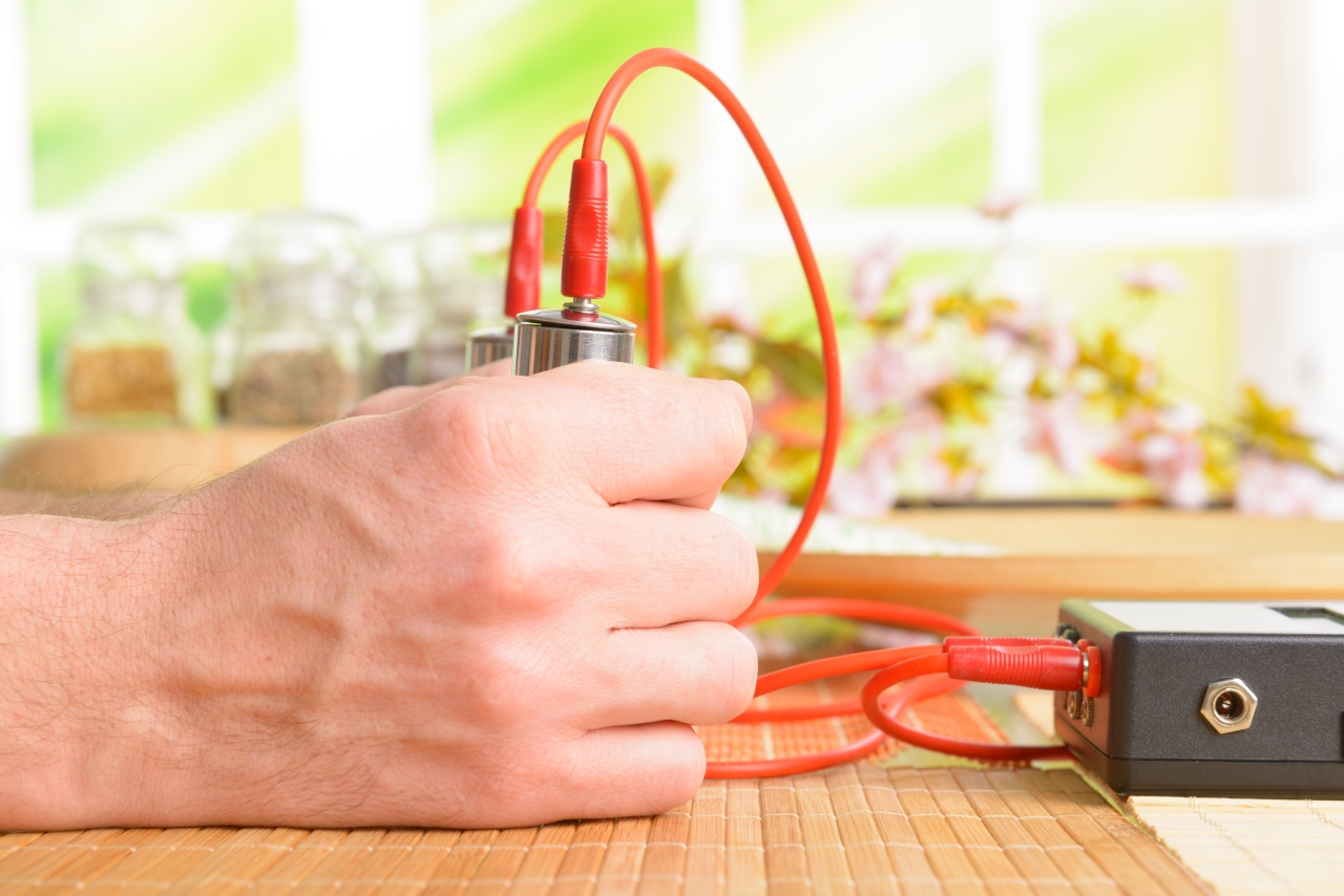 Hands holding electrodes of a bioresonance device